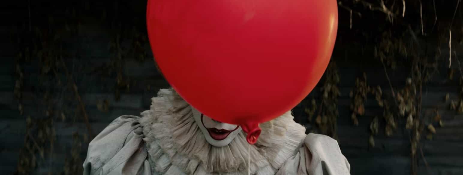 Stillbilde fra filmen «IT». En skummel klovn halvt skjult bak en rød ballong.