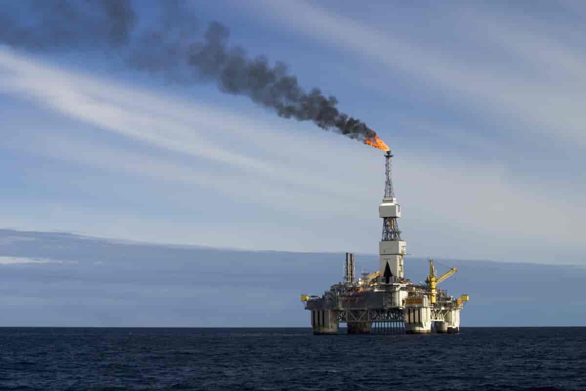 Foto som viser oljeplattform på Njordfeltet, det brennes gass fra et høyt tårn på plattformen. 