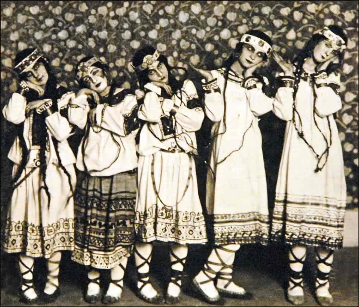 Fem unge dansere som står i tradisjonelle, russiske drakter.