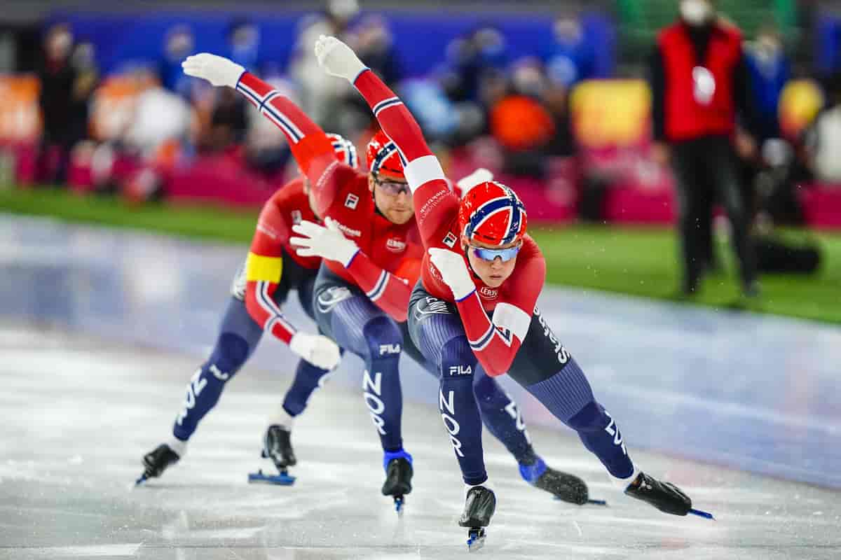 Tre skøyteløpere i norske landslagsdrakter rett etter hverandre.