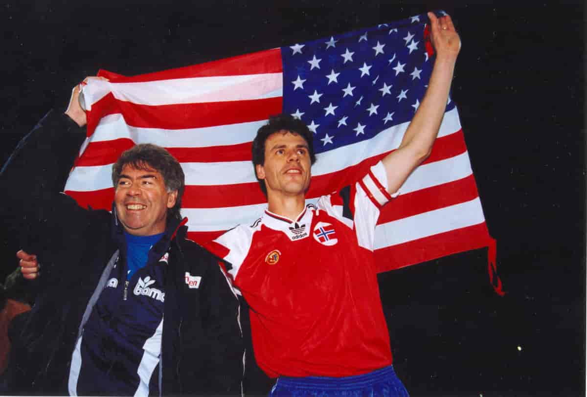 Egil Olsen og Rune Bratseth jubler etter seieren over Polen høsten 1993. De holder et norsk flagg bak seg. 