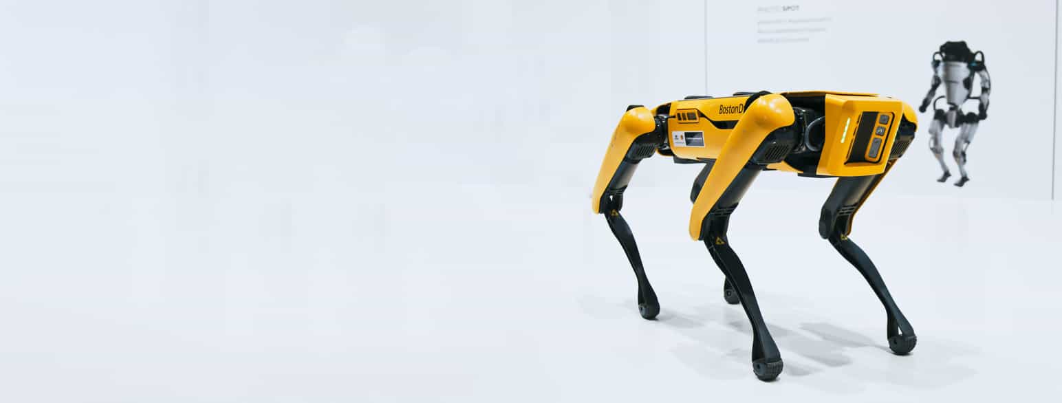 En gul robot med fire bein som ser ut som et dyr.