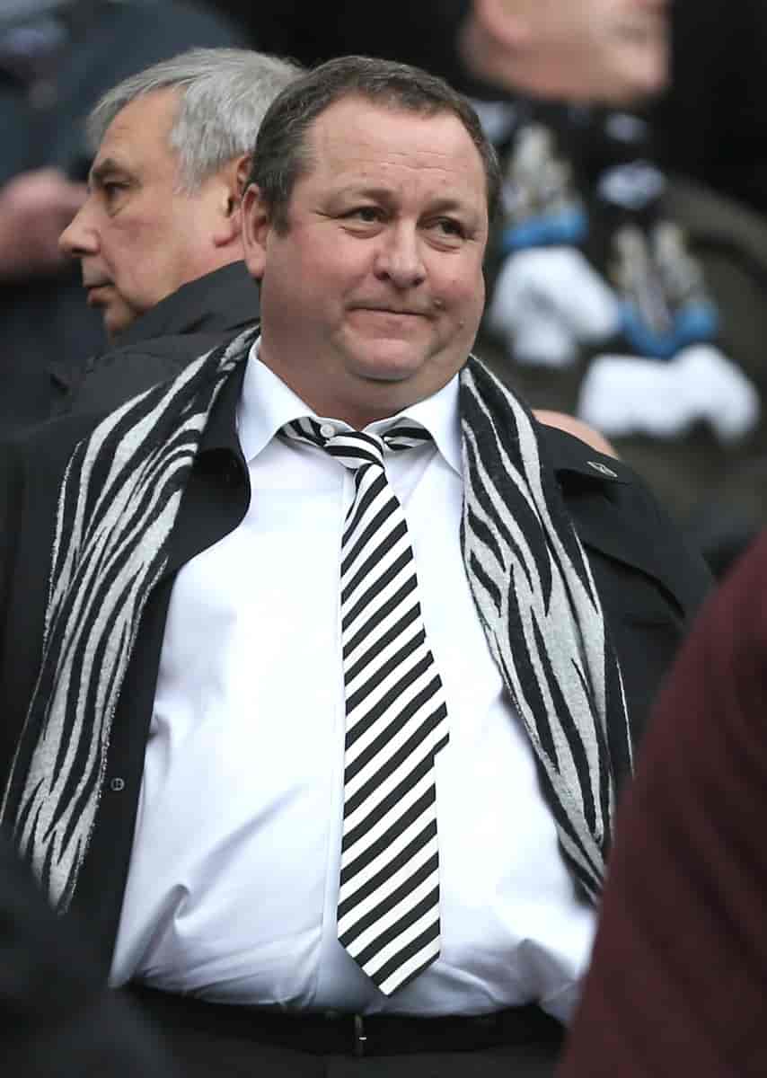 Mike Ashley i dress med et skjerf i Newcastles farger, svart og hvitt, rundt halsen.