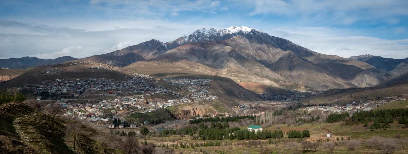 Foto landsbyer omgitt av høye fjell