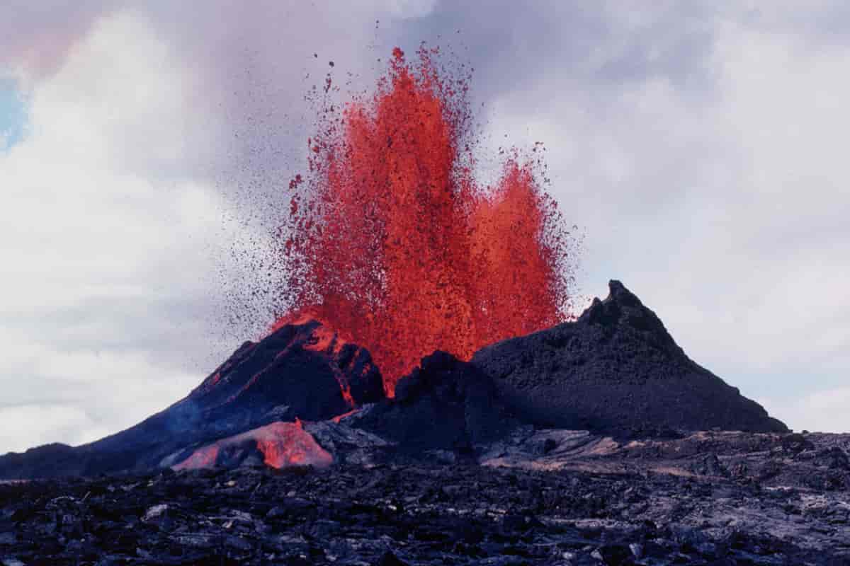 Bildet viser en vulkan som spruter ut rød lava mange meter opp i luften.