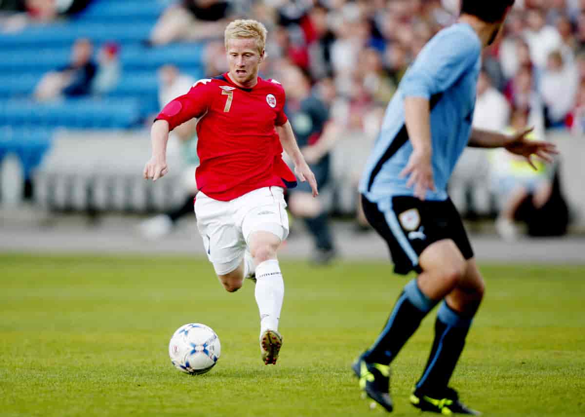 Strømstad løper med ballen i beina på en fotballbane mot en spiller fra motstanderlaget. 