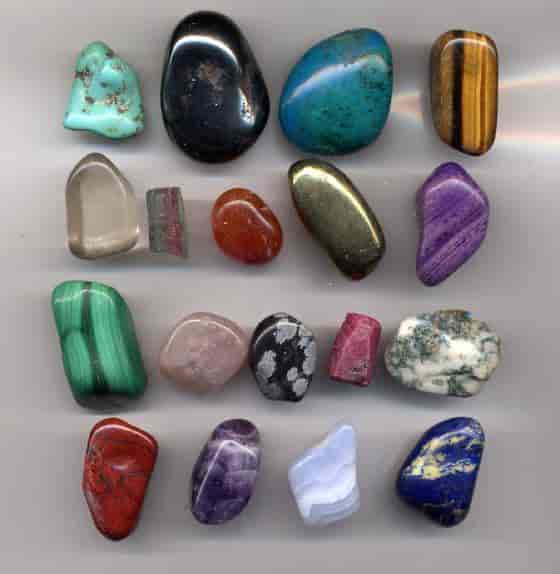 Flere ulike smykkesteiner som er polert så de er runde og myke i kantene. Det er mange forskjellige typer på bildet.