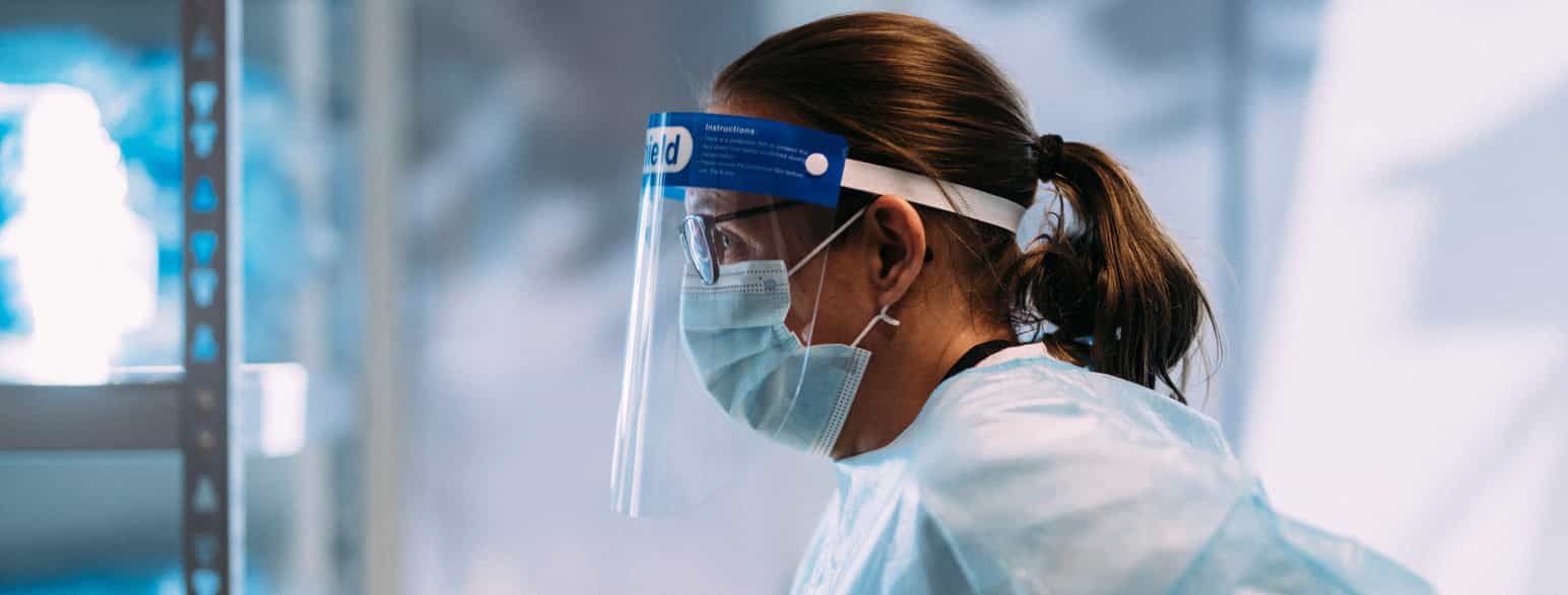 Foto av sykepleier med visir og munnbind