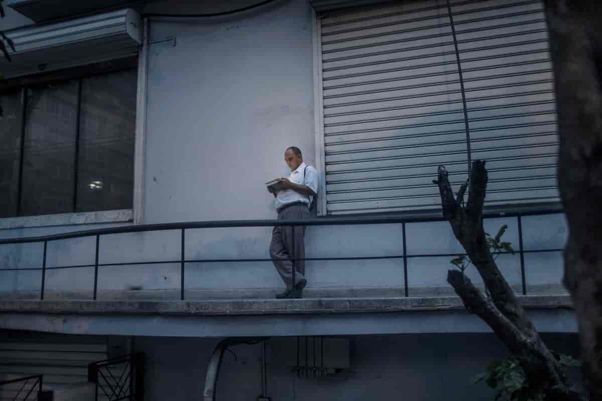 Mann sjekker internett utendørs på en balkong