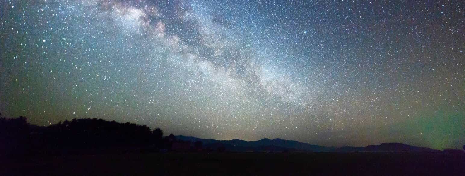 En nattehimmel sett fra Jorda med mange lysende stjerner.