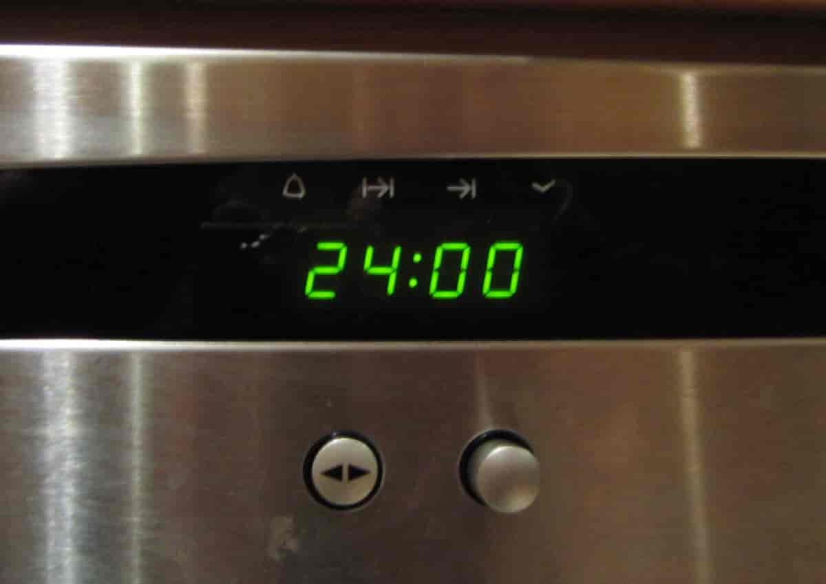 En klokke på en stekeovn som viser tallet 24:00.