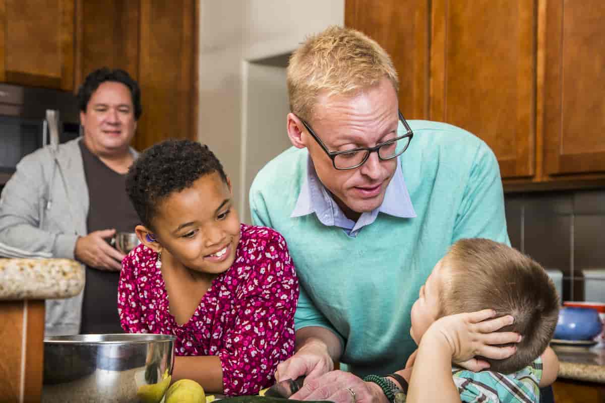 Foto av to voksne og to barn på et kjøkken