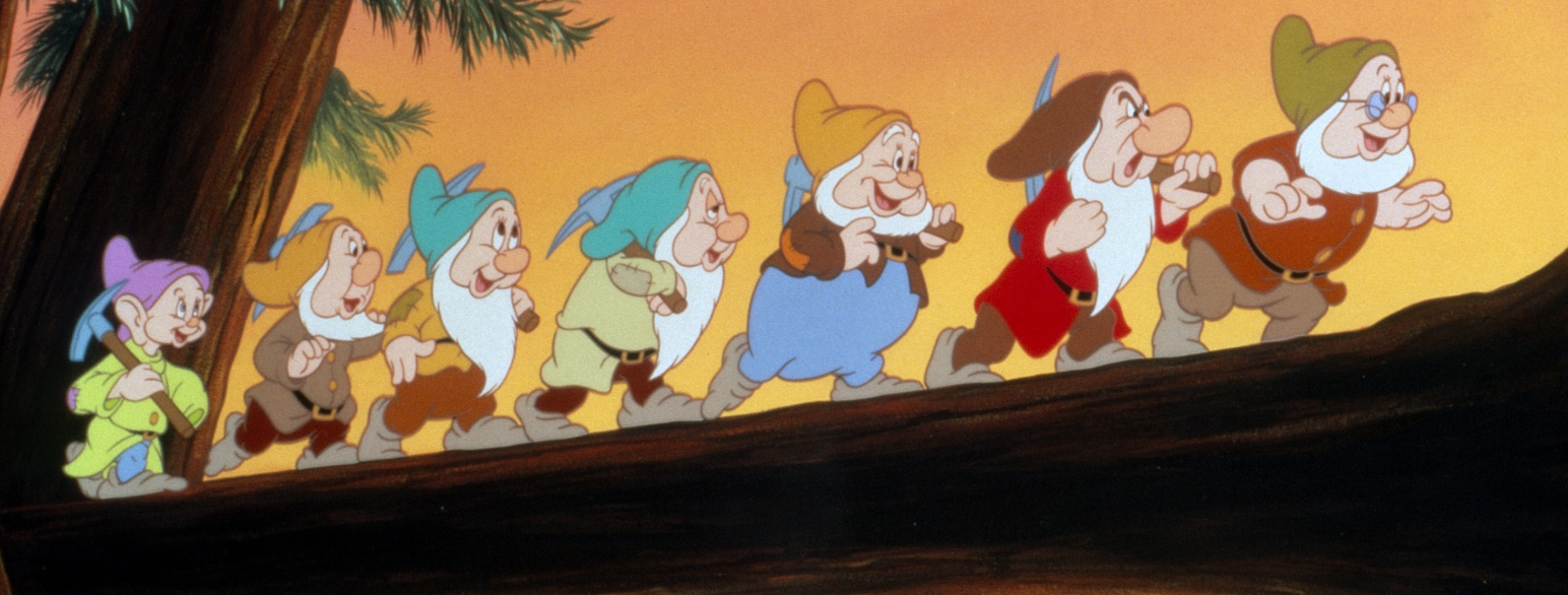 Et stillbilde fra tegnefilmen Snøhvit og de sju dvergene som viser de sju dvergene som går på rad på en tjukk grein. 