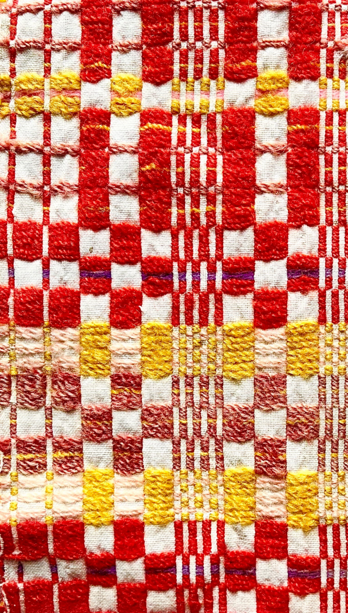 Et stykke vevd tøy med striper og ruter i ulike farger