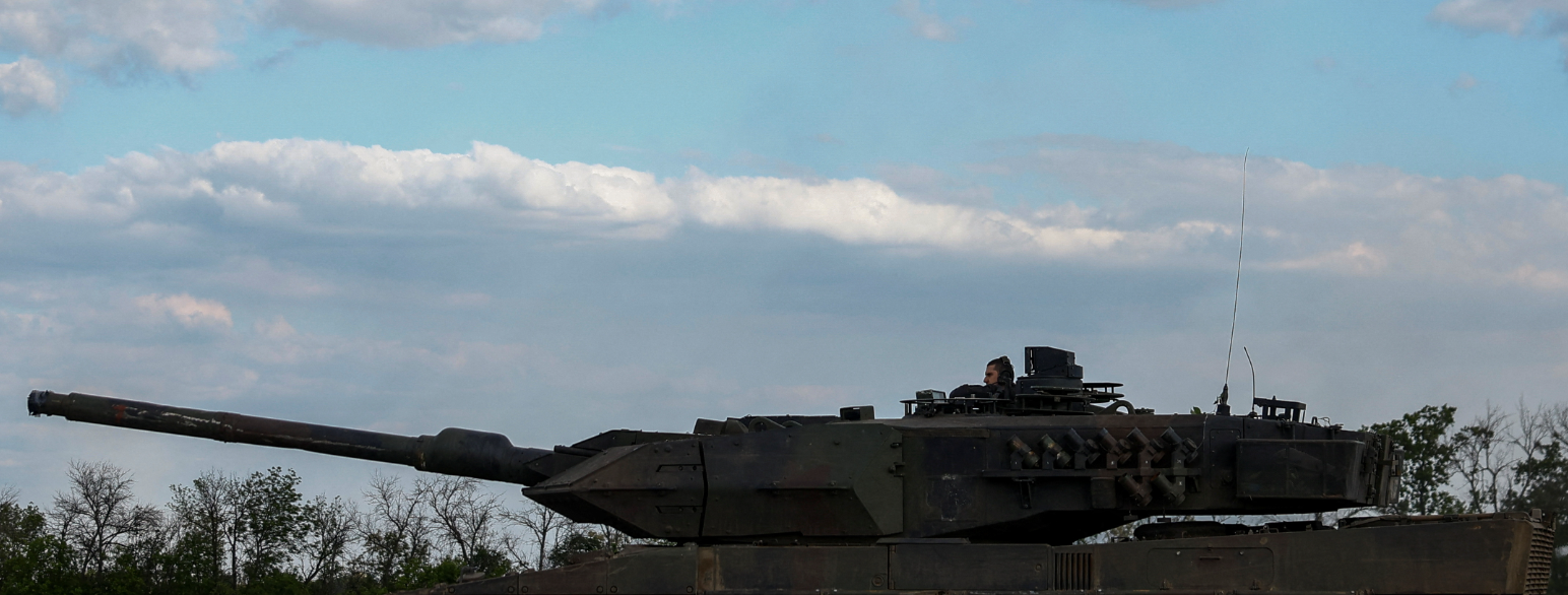 Foto av stridsvogn med fører sittende oppå.