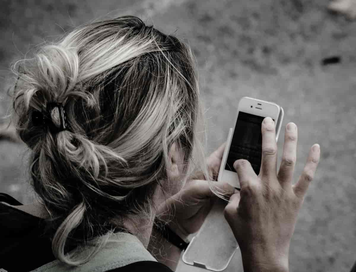 En kvinne som trykker på skjermen til en smarttelefon.