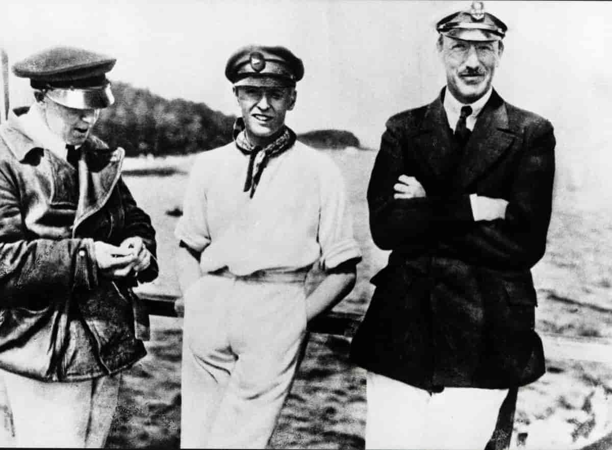 Foto av tre menn, kledd i maritime klær.
