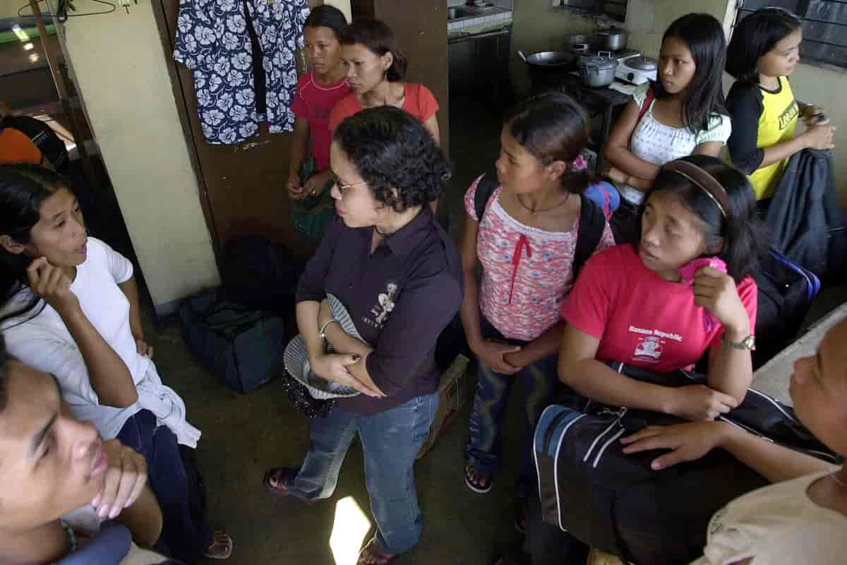 En sosialarbeider (i midten) snakker med antatte ofre for trafficking i Manila, Filippinene