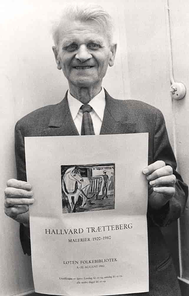 Hallvard Trætteberg holder en utstillingsplakat. På plakaten står det Halvard Trætteberg, malerier 1920-1980, Løten folkebibliotek.