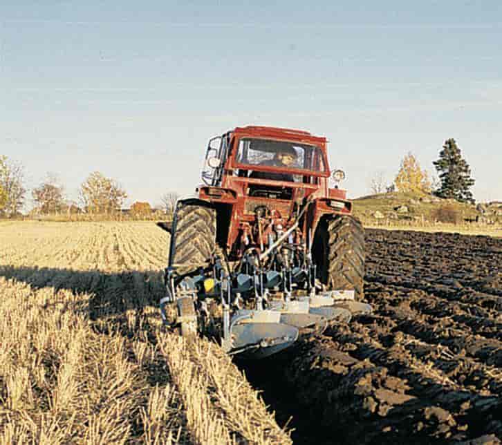 Traktor med fireskjærs bæreplog under høstpløying.