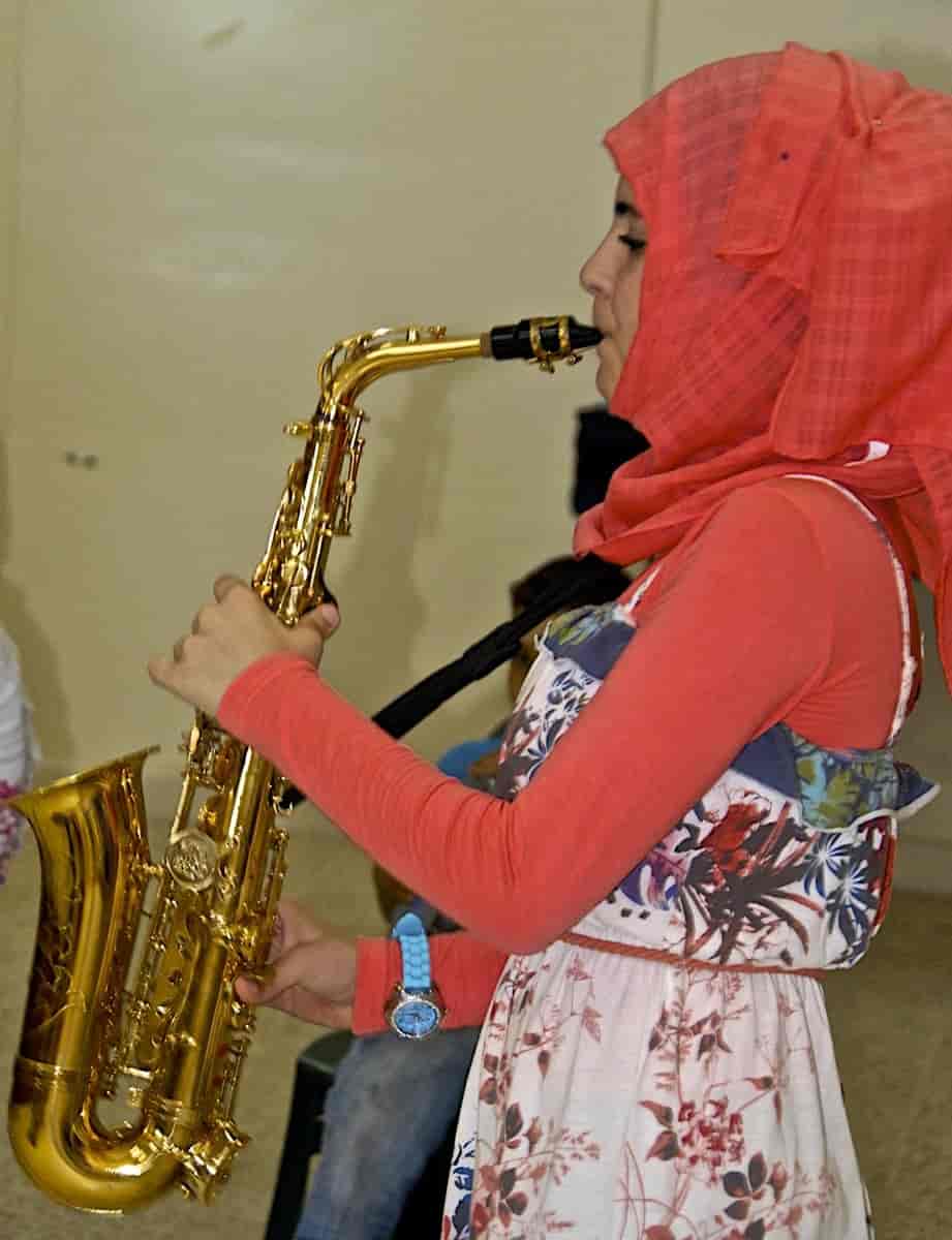 Kvinne spiller saksofon i et samfunnsmusikkterapeutisk prosjekt
