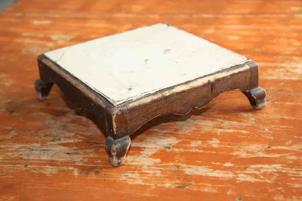 Bordskåner laget av en keramisk flis som er innfelt i en ramme med føtter
