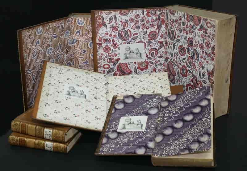 En samling eldre bøker med mønstret forsatspapir