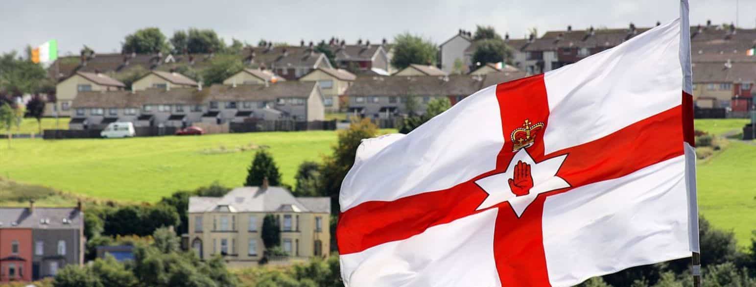 Det tidlegare nord-irske flagget (i front) har ikkje lenger noko offisiell status og brukast berre av unionistar. Den irske trikoloren (i bakgrunnen) brukast av nasjonalistane.  Her vaiar dei båe over ulike delar av byen Derry/Londonderry.
