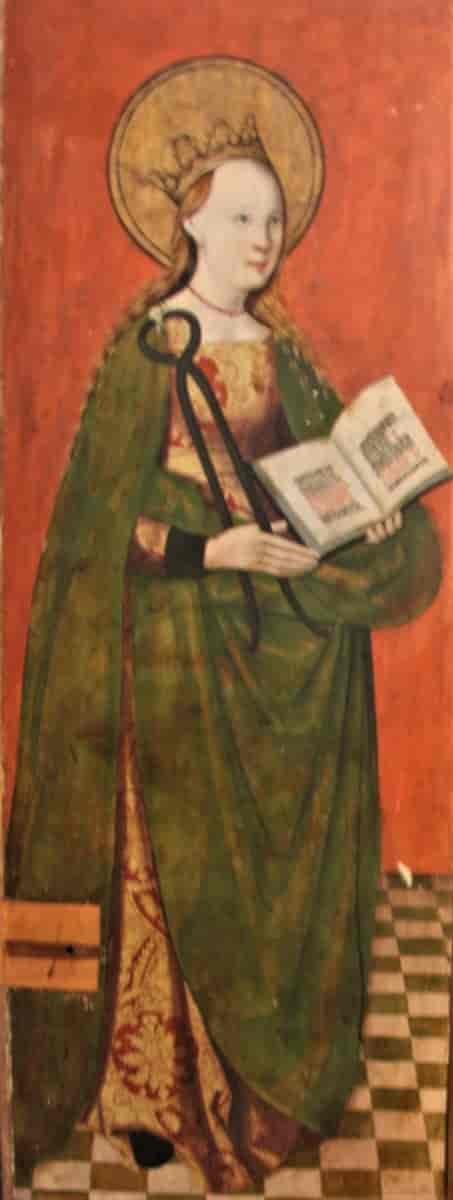 En typisk fremstilling av Sta. Apollonia med tang og tann i den ene hånden og en bok i den andre. Maleri på en fløydør i et alterskap i Aure kirke, Møre og Romsdal